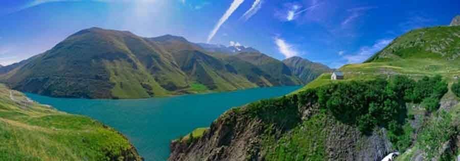 Panoramic mural of green mountains, blue river, and cozy house, perfect for indoor and outdoor spaces.