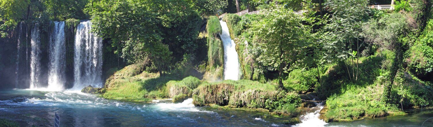 Panoramic view of Duden Waterfall in Turkey, showcasing cascading water and lush natural beauty.